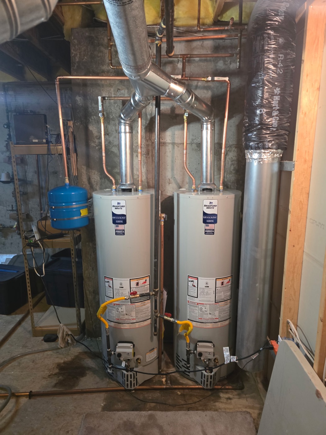 Water heater replacement: two Bradford White gas water heaters installed side by side with new copper manifold, expansion tank and venting in a Colorado basement
